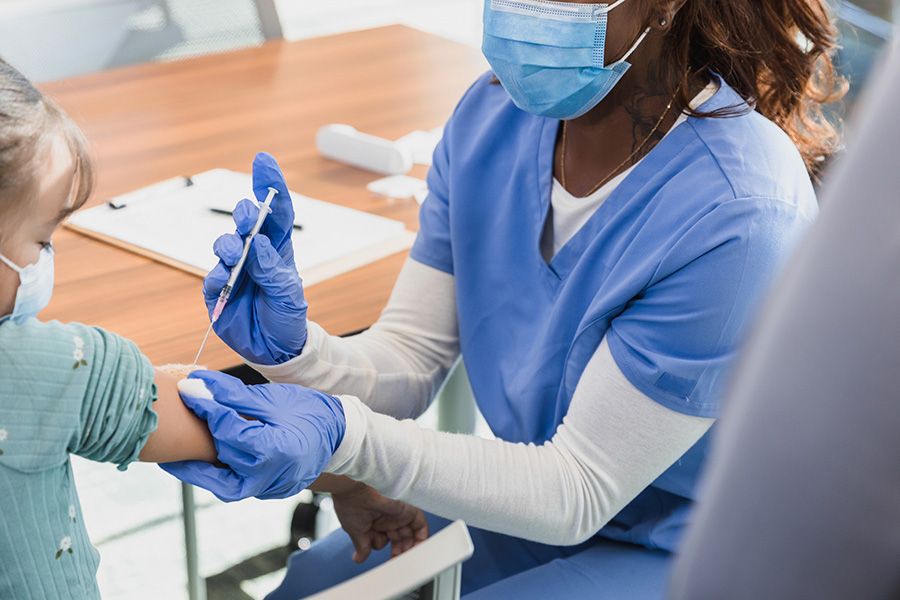 A nurse administers a vaccine into a patient's arm at a local clinic